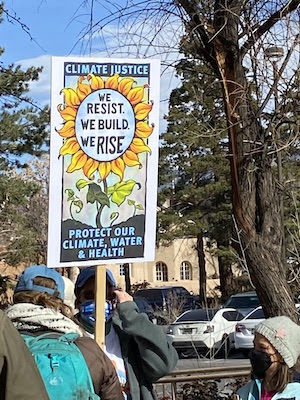 RALLY SIGNS AND CROWD AND THE ROUNDHOUSE NM STATE CAPITOL